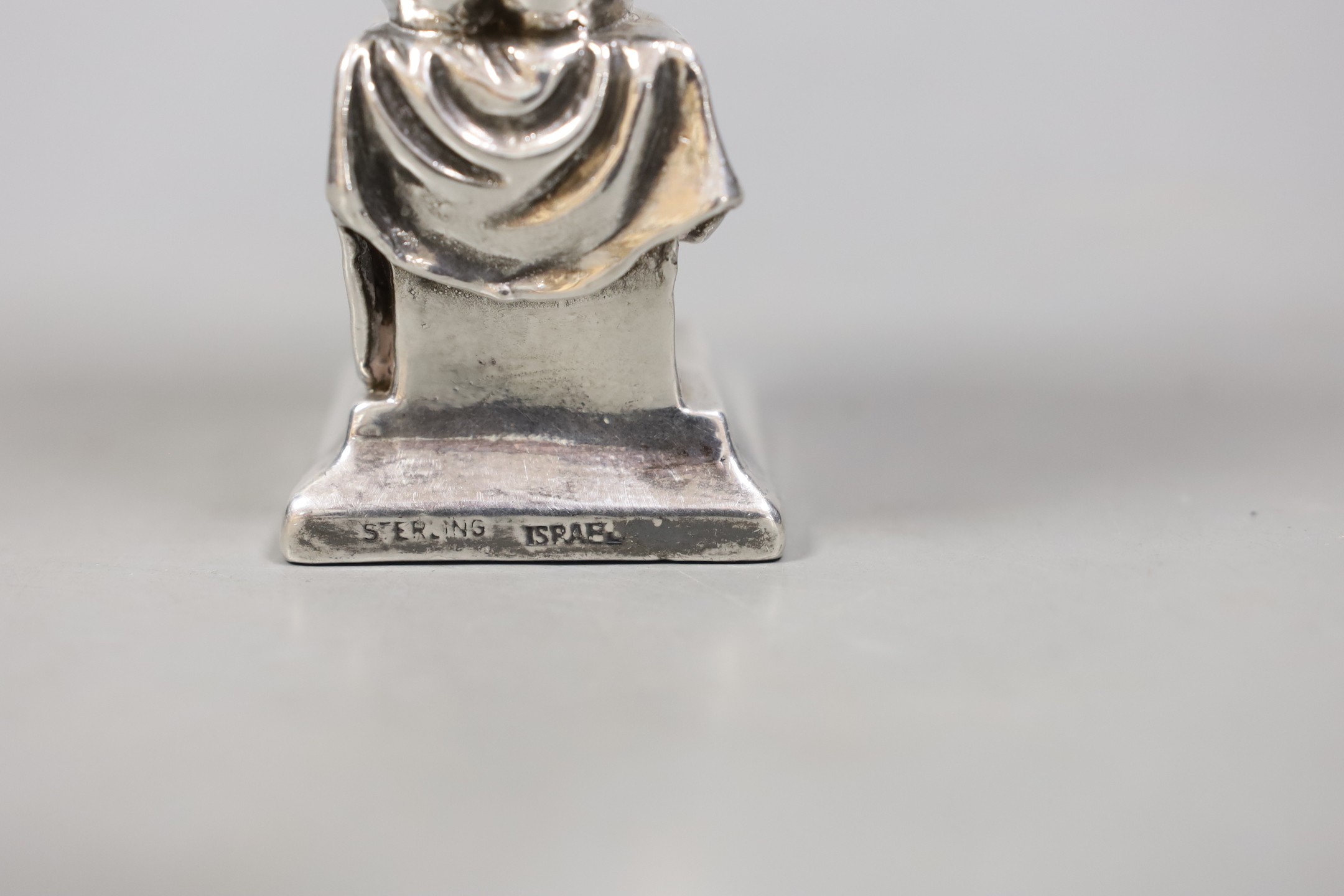 A modern Israeli sterling model of a seated young boy, reading, height 14.1cm.